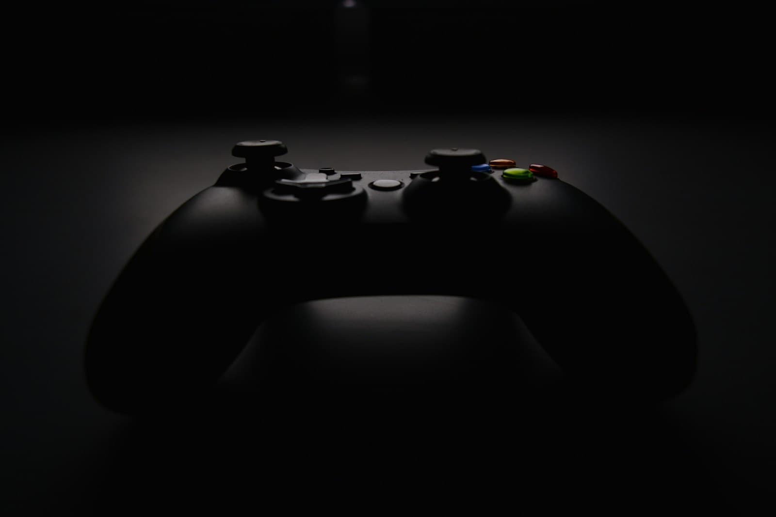 A black game controller in shadow